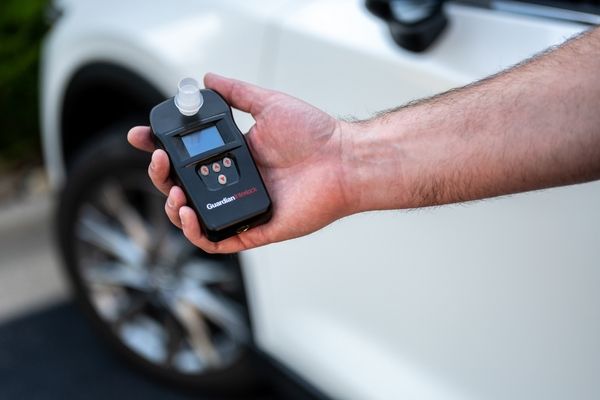 Ignition interlock device held in front of car